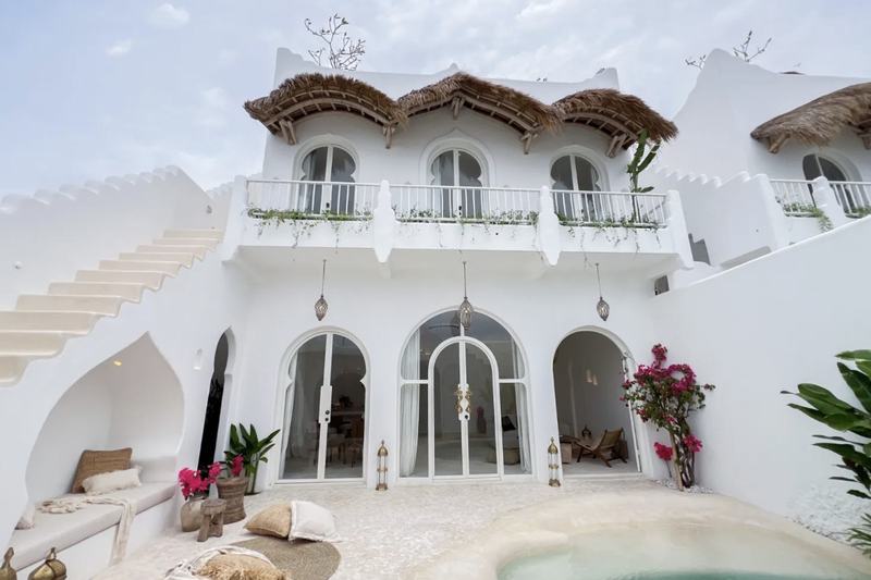 Casa Kayana: белый фасад виллы с арками и тростниковыми навесами — фото
