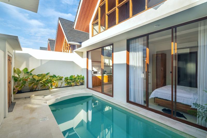 Sunset Village: бассейн во дворе виллы и спальня за стеклянными дверями — фото застройщика