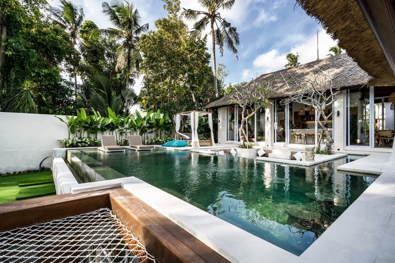 Вилла с четырьмя спальнями и бассейном в Ubud: бассейн и дома под соломенной крышей
